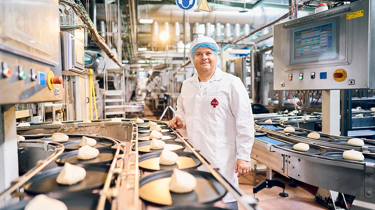 Mitarbeiter in Arbeitsklamotten an Produktionsband.