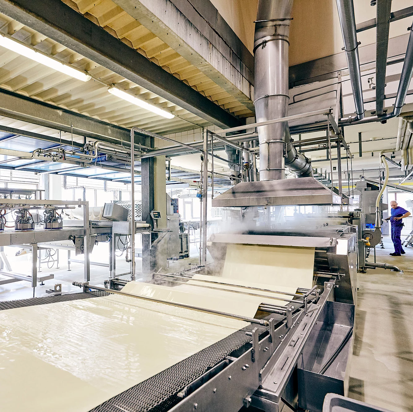 Produktionsmaschine mit ausgerolltem Pizzateig.