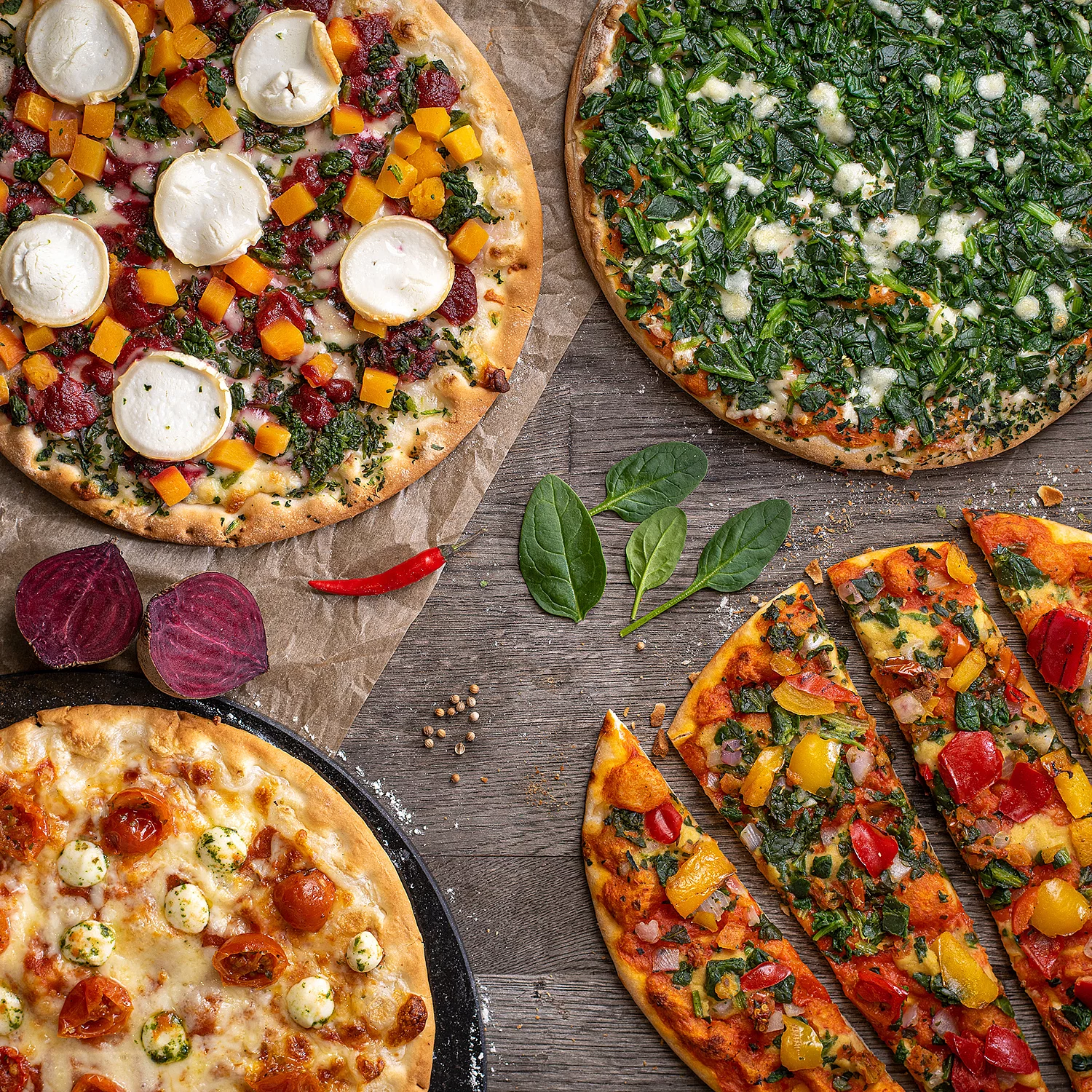 Vier angerichtete Pizzen mit Tomate Mozarella, Paprika, Spinat und Ziegenkäse.