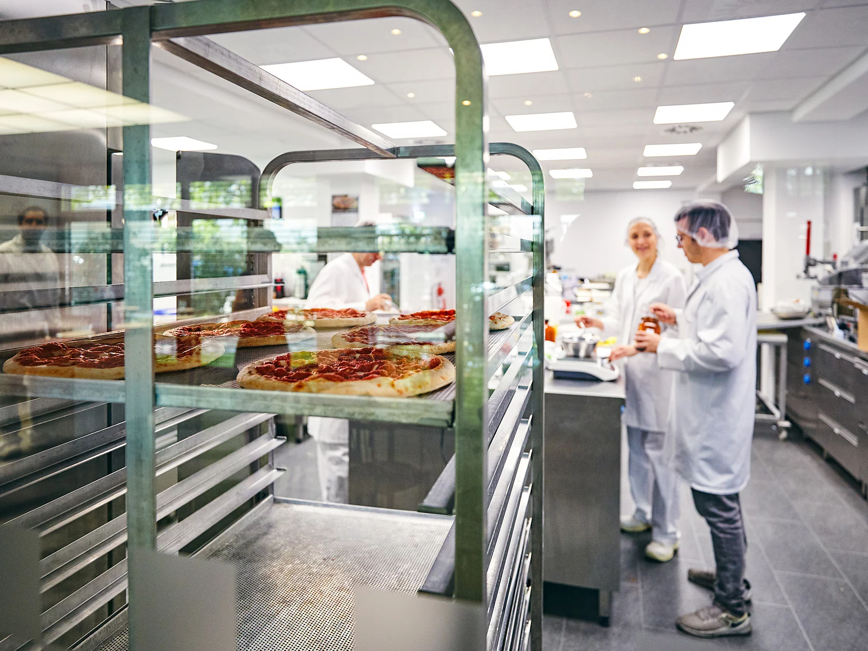 Mitarbeitende in Arbeitskleidung in der Produktionsküche.